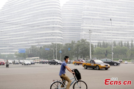 A cyclist wearing a face mask rides on a street on a smoggy day in Beijing, June 23, 2015.(Photo: China News Service/Li Huisi) A cyclist wearing a face mask rides on a street on a smoggy day in Beijing, June 23, 2015.(Photo: China News Service/Li Huisi)