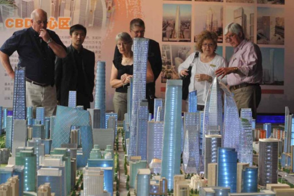 Foreigners look at real estate project models at a central business district (CBD) in Beijing. (File photo) Foreigners look at real estate project models at a central business district (CBD) in Beijing. (File photo)