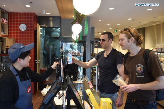 Tim Clancy (C), an Australian who has lived in Hangzhou for six years with his Chinese wife, takes his American friend to buy coffee and bread through mobile payment in Hangzhou, capital of east China's Zhejiang Province, April 14, 2017. (Xinhua/Huang Zongzhi) Tim Clancy (C), an Australian who has lived in Hangzhou for six years with his Chinese wife, takes his American friend to buy coffee and bread through mobile payment in Hangzhou, capital of east China's Zhejiang Province, April 14, 2017. (Xinhua/Huang Zongzhi)