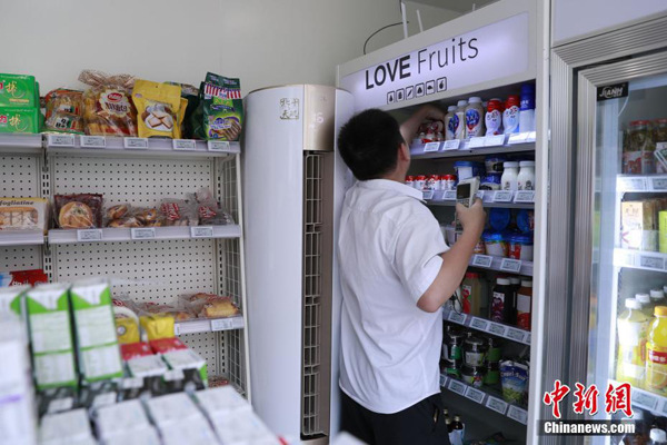 An employee stocks a refrigerator in the unmanned convenience store on Wednesday. (Photo/Chinanews.com)