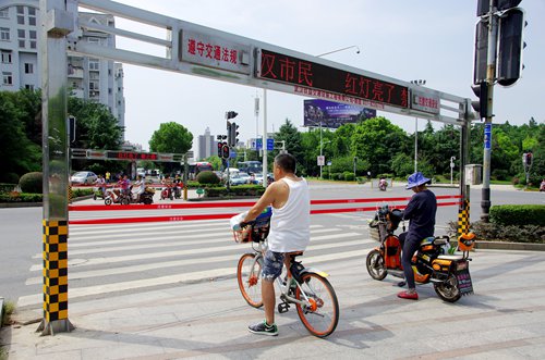 People wait at a new anti-jaywalking gate installed at a major intersection in Wuhan, Central China's Hubei Province. (Photo/China News Service) People wait at a new anti-jaywalking gate installed at a major intersection in Wuhan, Central China's Hubei Province. (Photo/China News Service)