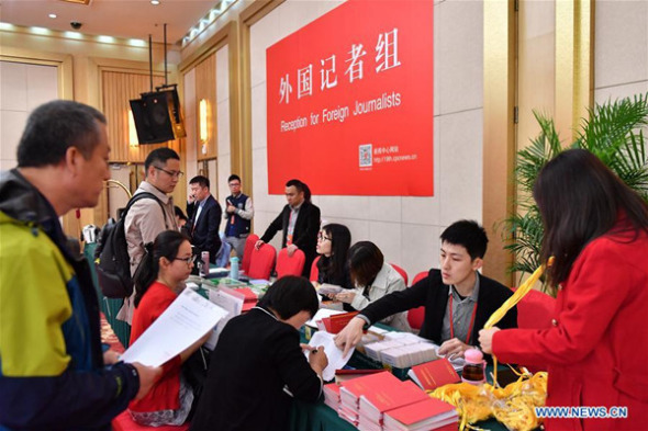Staff members work at the reception for foreign journalists in the Press Center of the 19th National Congress of the Communist Party of China in Beijing, capital of China, Oct. 11, 2017. (Xinhua/Li Xin)