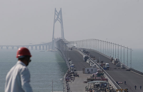Workers are finishing up construction of the Hong Kong-Zhuhai-Macao Bridge, the world's longest bridge-tunnel complex. It stretches a total of 55 kilometers. (Roy Liu/China Daily) Workers are finishing up construction of the Hong Kong-Zhuhai-Macao Bridge, the world's longest bridge-tunnel complex. It stretches a total of 55 kilometers. (Roy Liu/China Daily)