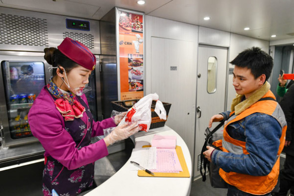 A courier delivers a food order for passengers to an attendent on a high-speed train in Chongqing on Feb 9, 2018.(Photo/Xinhua) A courier delivers a food order for passengers to an attendent on a high-speed train in Chongqing on Feb 9, 2018.(Photo/Xinhua)