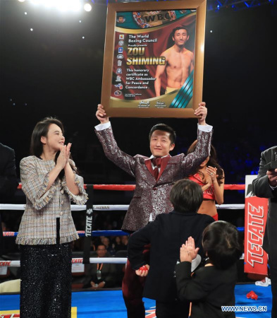 China's boxer Zou Shiming (Top, R) holds the certification of Ambassador of Peace and Concordance presented by Mauricio Sulaiman, the President of the World Boxing Council (WBC) in Los Angeles, theUnited States, Feb. 24, 2018. Zou received Award of Honor and the title of Ambassador of Peace and Concordance by WBC here Saturday. (Xinhua/Li Ying)