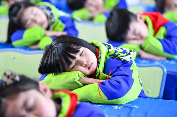 Elementary school students practice a healthy position for napping in Bozhou, Anhui province, on Wednesday, which was World Sleep Day.(Photo by Liu Qinli/for China Daily) Elementary school students practice a healthy position for napping in Bozhou, Anhui province, on Wednesday, which was World Sleep Day.(Photo by Liu Qinli/for China Daily)