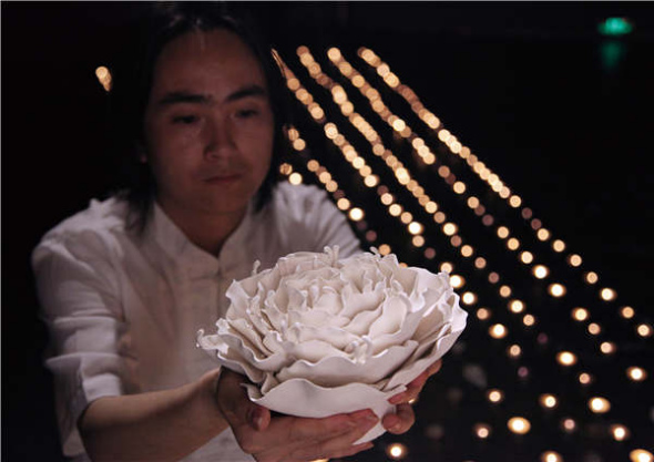 Parents of twin girls donating the ashes to Shu Yong, which the artist blended with clay to create flower sculptures. (Photo provided to China Daily) Parents of twin girls donating the ashes to Shu Yong, which the artist blended with clay to create flower sculptures. (Photo provided to China Daily)