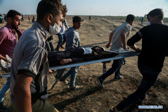 Palestinians carry an injured man during clashes with Israeli troops near the Gaza-Israel border, east of Gaza City, on May 15, 2018. (Xinhua) Palestinians carry an injured man during clashes with Israeli troops near the Gaza-Israel border, east of Gaza City, on May 15, 2018. (Xinhua)