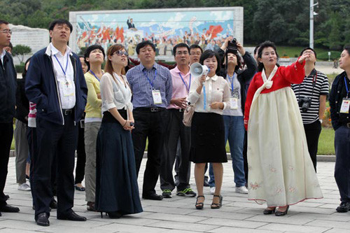 Chinese tourists, accompanied by local tour guides, look at the Arch of Triumph in Pyongyang, Democratic People's Republic of Korea, in September. Feng Yongbin / China Daily