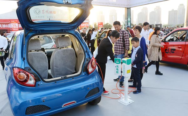 Visitors to an auto show check a charging post. The country is tightening its subsidy policies on new-energy vehicles in an attempt to transform the market from policy-driven.(Photo/China Daily) Visitors to an auto show check a charging post. The country is tightening its subsidy policies on new-energy vehicles in an attempt to transform the market from policy-driven.(Photo/China Daily)