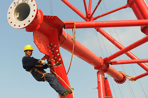 A State Grid employee works on an ultra-high-voltage transmission construction in Huainan, Anhui province. (Photo for China Daily by Song Weixing) A State Grid employee works on an ultra-high-voltage transmission construction in Huainan, Anhui province. (Photo for China Daily by Song Weixing)