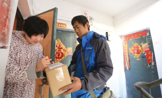 A 26-year-old woman receives goods she bought online in Dalian, Liaoning province. (Photo provided to China Daily)