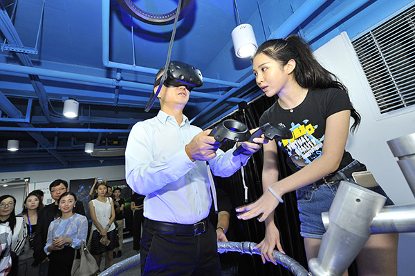 An executive from internet giant Tencent Holdings Ltd experiences a pilot virtual reality device at an entrepreneurship event in Fuzhou, East China's Fujian province. (Photo/China Daily) An executive from internet giant Tencent Holdings Ltd experiences a pilot virtual reality device at an entrepreneurship event in Fuzhou, East China's Fujian province. (Photo/China Daily)