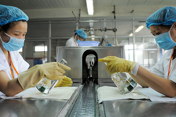 Workers check packaged liquor at a workshop of Shuijingfang Group Co Ltd in Chengdu, capital of Sihuan province. (Photo/Xinhua)