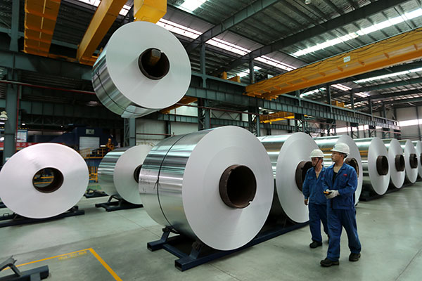 Two workers walk past a production line of an aluminum plant in Suixi county, Anhui province. WAN SHANCHAO / FOR CHINA DAILY Two workers walk past a production line of an aluminum plant in Suixi county, Anhui province. WAN SHANCHAO / FOR CHINA DAILY