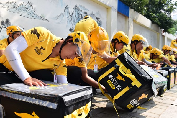 Couriers of an online food delivery company check the delivery boxes. Photo/Xinhua Couriers of an online food delivery company check the delivery boxes. Photo/Xinhua