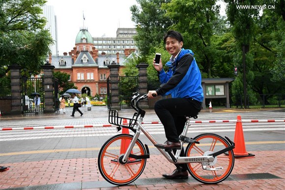 A TV reporter tries out a shared bicycle in Sapporo, Japan, on Aug. 22, 2017.(Xinhua/Hua Yi) A TV reporter tries out a shared bicycle in Sapporo, Japan, on Aug. 22, 2017.(Xinhua/Hua Yi)