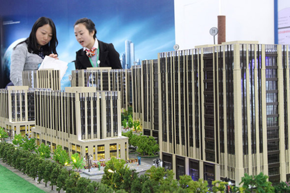 Visitors look at a model of a housing project at a real estate exhibition in Beijing. (Photo provided to China Daily) Visitors look at a model of a housing project at a real estate exhibition in Beijing. (Photo provided to China Daily)