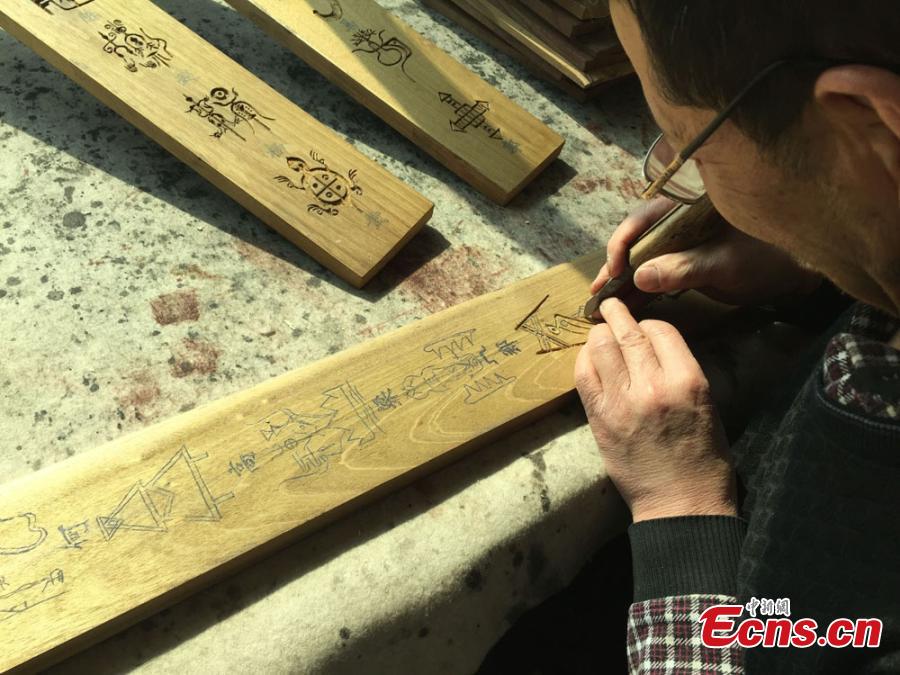Devoted artist carves pictograph on wood to showcase Chinese surnames(1/5)