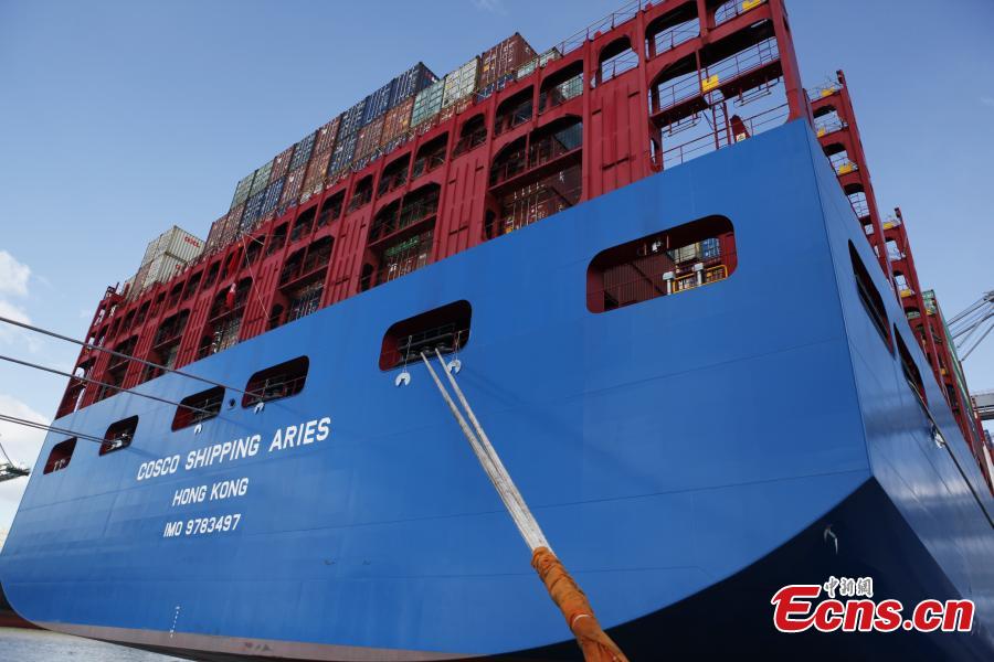 China\'s colossal container vessel COSCO Shipping Aries docks at the Port of Antwerp in Belgium during its maiden voyage, Feb. 27, 2018. The 20,000 TEU vessel is the first ultra-large containership built and operated by a Chinese company. COSCO Shipping Aries is 400 meters long, 58.6 meters wide and 30.7 meters high, with a maximum load capacity of 197,000 tons. Its deck area is larger than four standard soccer stadiums. (Photo: China News Service/De Yongjian)