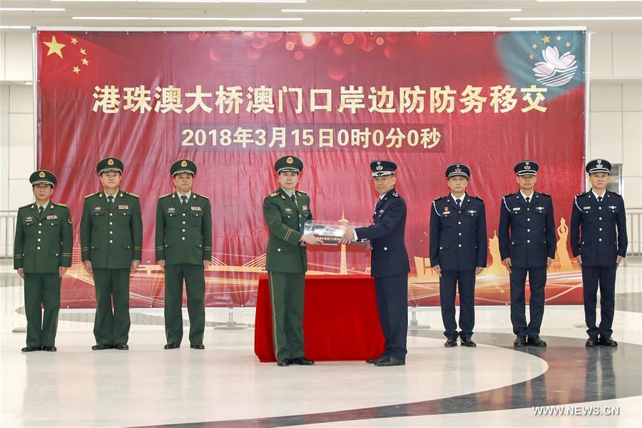 A representative from Guangdong province gave a representative from Macao a model of the artificial island of the bridge during a handover ceremony held at the Macao border zone building on the artificial island of the Hong Kong-Zhuhai-Macao Bridge, south China, March 15, 2018. The Macao border zone of the world\'s longest sea bridge connecting Hong Kong, Zhuhai and Macao was officially handed over to Macao on Thursday, Macao\'s Government Spokesperson\'s Office said in a statement. (Xinhua)