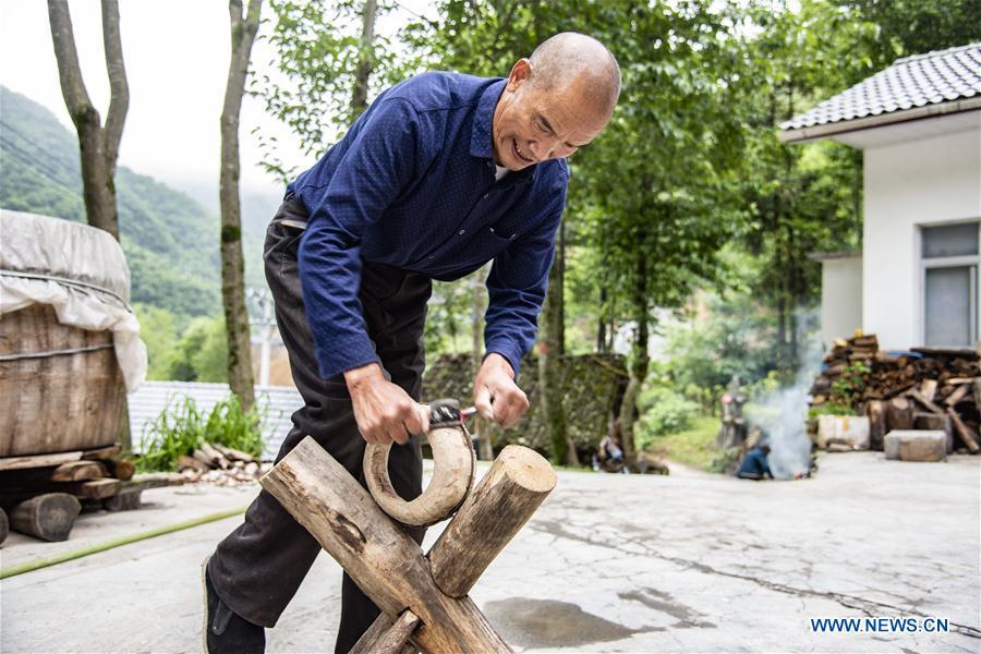 Wu Kaixue makes a Dingtang drum at his courtyard in Longtan Village, Shennongjia of central China\'s Hubei Province, May 21, 2018. Wu Kaixue, who is 75 years old, began to learn the making of Dingtang drums when he was 13. The making of Dingtang drums needs natural resources from the Shennongjia forest and also requires high standard of techniques. Wu makes 100 plus drums in a year and his fame has spread far away. (Xinhua/Du Huaju)