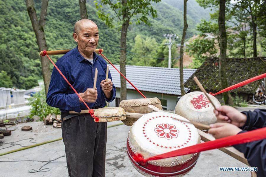 Wu Kaixue shows how to beat the Dingtang drum at his courtyard in Longtan Village, Shennongjia of central China\'s Hubei Province, May 21, 2018. Wu Kaixue, who is 75 years old, began to learn the making of Dingtang drums when he was 13. The making of Dingtang drums needs natural resources from the Shennongjia forest and also requires high standard of techniques. Wu makes 100 plus drums in a year and his fame has spread far away. (Xinhua/Du Huaju)