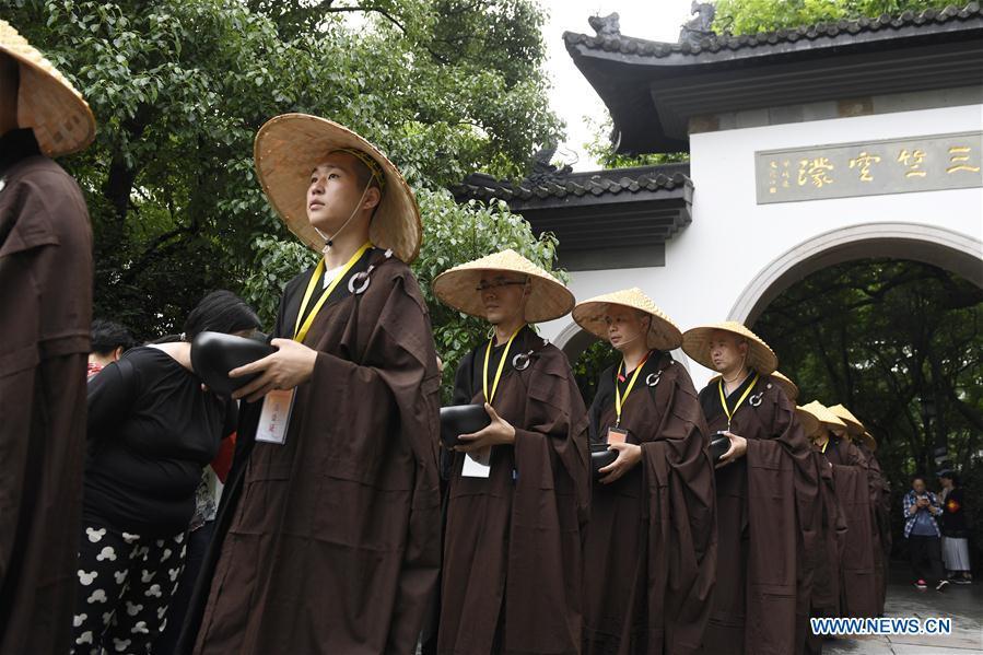 Monks holding bowls receive donation from residents and tourists in Hangzhou, capital of east China\'s Zhejiang Province, on May 22, 2018. Altogether 1,000 monks in Hangzhou participated in a traditional mendicants\' walk on Tuesday to walk from Faxi Temple to Lingyin Temple for charity. All the donation received along the way will be donated to charity.(Xinhua/Huang Zongzhi)