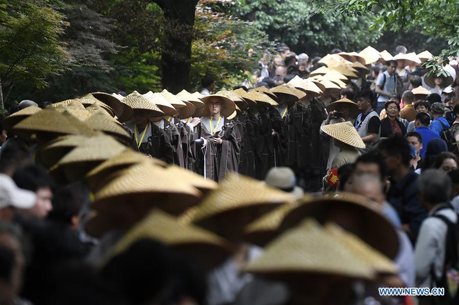 Monks holding bowls walk towards Lingyin Temple in Hangzhou, capital of east China\'s Zhejiang Province, on May 22, 2018. Altogether 1,000 monks in Hangzhou participated in a traditional mendicants\' walk on Tuesday to walk from Faxi Temple to Lingyin Temple for charity. All the donation received along the way will be donated to charity. (Xinhua/Huang Zongzhi)