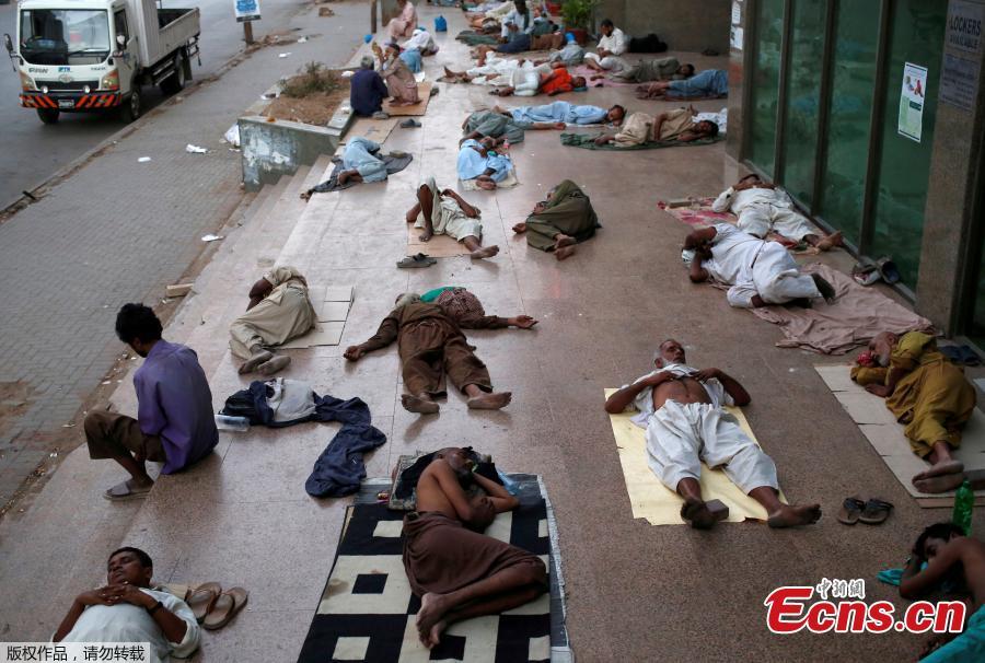 Residents sleep on a building pavement, to escape heat and frequent power outage in their residence area Karachi, Pakistan, May 22, 2018. The Meteorological Department has issued a heat-wave alert for three days. (Photo/Agencies)