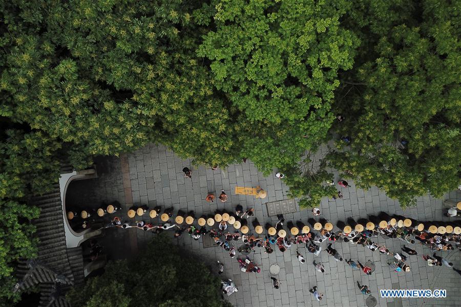 Monks holding bowls walk towards Lingyin Temple in Hangzhou, capital of east China\'s Zhejiang Province, on May 22, 2018. Altogether 1,000 monks in Hangzhou participated in a traditional mendicants\' walk on Tuesday to walk from Faxi Temple to Lingyin Temple for charity. All the donation received along the way will be donated to charity.(Xinhua/Huang Zongzhi)