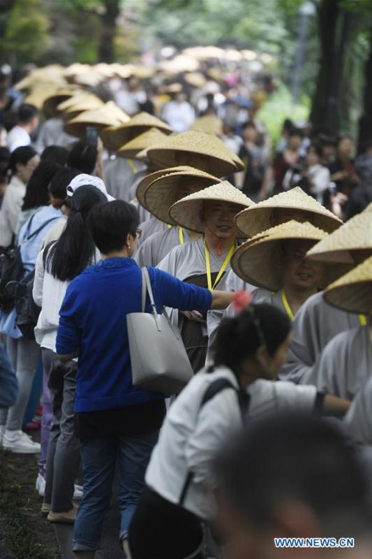 Monks holding bowls receive donation from residents and tourists in Hangzhou, capital of east China\'s Zhejiang Province, on May 22, 2018. Altogether 1,000 monks in Hangzhou participated in a traditional mendicants\' walk on Tuesday to walk from Faxi Temple to Lingyin Temple for charity. All the donation received along the way will be donated to charity.(Xinhua/Huang Zongzhi)