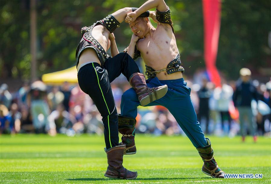 Two wrestlers of Hohhot Minzu College compete at a Nadam fair of the school in Hohhot, north China\'s Inner Mongolia Autonomous Region, May 23, 2018. (Xinhua/Ding Genhou)
