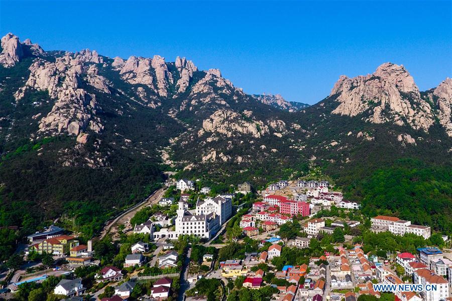 Aerial photo taken on May 19, 2018 shows a scene of a village at the foot of the Laoshan Mountain in Qingdao, east China\'s Shandong Province. (Xinhua/Guo Xulei)