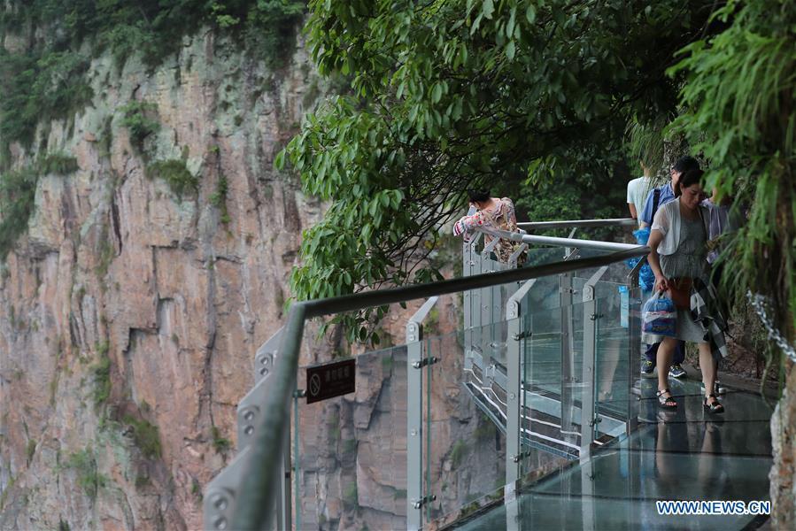 People walk on the Lingyundu glass trestle in the Xuedou Mountain in Ningbo City, east China\'s Zhejiang Province, May 26, 2018. The glass trestle was opened to tourists on Saturday. (Xinhua/Zhang Peijian)