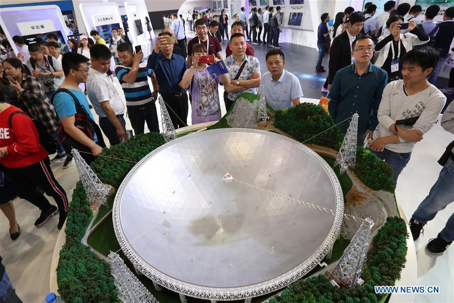 People look at a model of China\'s Five-hundred-meter Aperture Spherical Radio Telescope (FAST), the world\'s largest single-dish radio telescope, during the International Big Data Industry Expo in Guiyang, capital of southwest China\'s Guizhou Province, May 26, 2018. The four-day expo opened here on Saturday, attracting over 40,000 participants from nearly 30 countries. (Xinhua/Liu Xu)