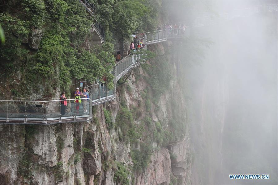 People are seen on the Lingyundu glass trestle in the Xuedou Mountain in Ningbo City, east China\'s Zhejiang Province, May 26, 2018. The glass trestle was opened to tourists on Saturday. (Xinhua/Zhang Peijian)