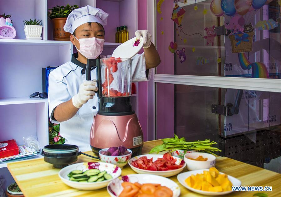 A villager makes vegetable and fruit juice in Zhaozijian Village, Zaoqiang County of north China\'s Hebei Province, May 26, 2018. Buns made from pumpkin, spinach, cabbage and other vegetable and fruit in Zaoqiang County are popular in supermarkets and online shops. (Xinhua/Li Xiaoguo)