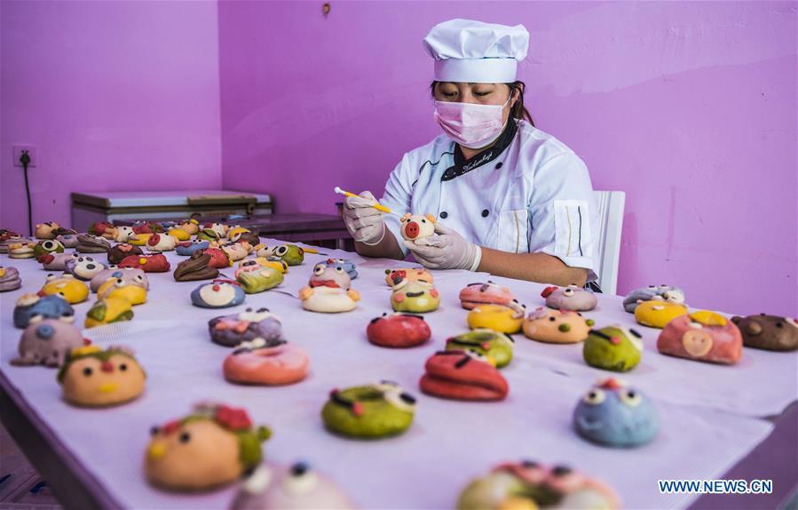 A villager makes vegetable and fruit buns in Zhaozijian Village, Zaoqiang County of north China\'s Hebei Province, May 26, 2018. Buns made from pumpkin, spinach, cabbage and other vegetable and fruit in Zaoqiang County are popular in supermarkets and online shops. (Xinhua/Li Xiaoguo)