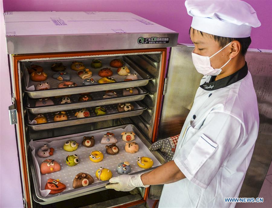 A villager takes out steamed buns made from vegetable and fruit in Zhaozijian Village, Zaoqiang County of north China\'s Hebei Province, May 26, 2018. Buns made from pumpkin, spinach, cabbage and other vegetable and fruit in Zaoqiang County are popular in supermarkets and online shops. (Xinhua/Li Xiaoguo)