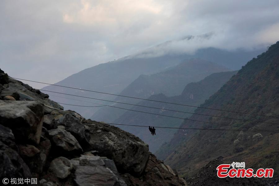 A family is ready to zip their way back to a village after shopping at a market in Nujiang Lisu Autonomous Prefecture in Southwest China’s Yunnan Province. Villagers have to use a zipline to cross the raging river. (Photo/VCG)