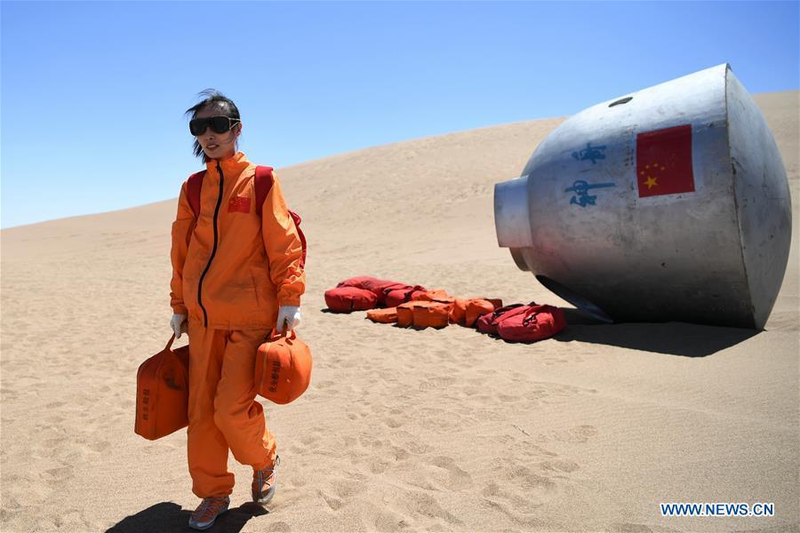 Taikonaut Wang Yaping participates in a wilderness survival training in the Badain Jaran Desert in northwest China\'s Gansu Province, May 22, 2018. Fifteen Chinese taikonauts have just completed desert survival training deep in the Badain Jaran Desert near Jiuquan Satellite Launch Center in northwest China. Organized by the Astronaut Center of China (ACC), the program was designed to prepare taikonauts with the capacity to survive in the wilderness in the event their re-entry capsule lands off target. (Xinhua/Chen Bin)