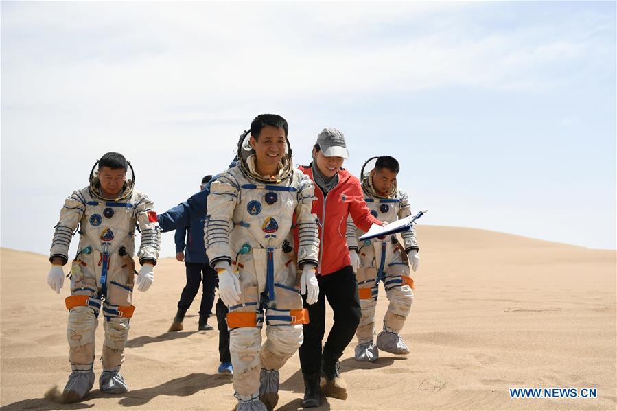 Taikonauts Nie Haisheng (3rd R), Liu Wang (1st L) and Zhang Xiaoguang (1st R) participate in a wilderness survival training in the Badain Jaran Desert in northwest China\'s Gansu Province, May 17, 2018. Fifteen Chinese taikonauts have just completed desert survival training deep in the Badain Jaran Desert near Jiuquan Satellite Launch Center in northwest China. Organized by the Astronaut Center of China (ACC), the program was designed to prepare taikonauts with the capacity to survive in the wilderness in the event their re-entry capsule lands off target. (Xinhua/Chen Bin)