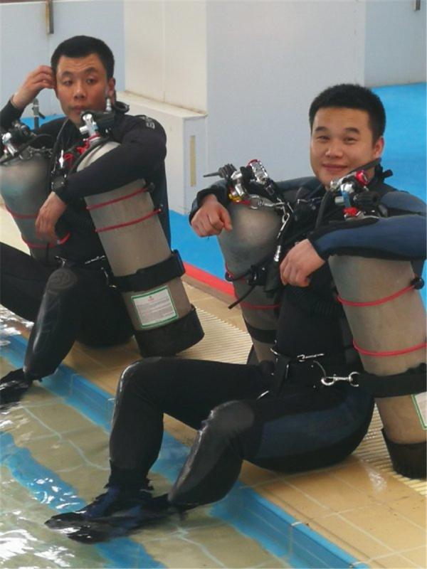 Chen Chao (left) and one of his colleagues take a break after a training session. (Photo provided to China Daily)
Chen Chao, who became a police diver in 2007, said a newcomer could learn diving techniques in just a year, but that was only part of the job, and the nature of the work meant that even a successful mission could leave squad members without a sense of accomplishment.
In 2011, Chen was assigned to search for the bodies of two children - a 5-year-old girl and a 6-year-old boy - who were killed and thrown in a river in downtown Beijing.
Chen, a sports graduate who learned how to swim at age 7, said it was the most haunting moment in his 11-year career and one he still remembers often.