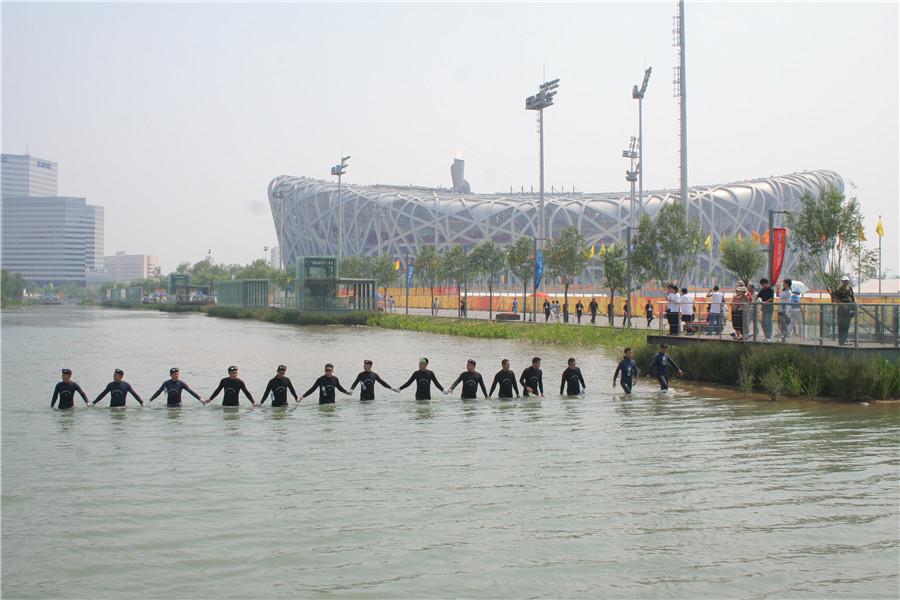 The squad\'s divers conduct security checks in the waterway beside Beijing\'s National Stadium. (Photo provided to China Daily)
\