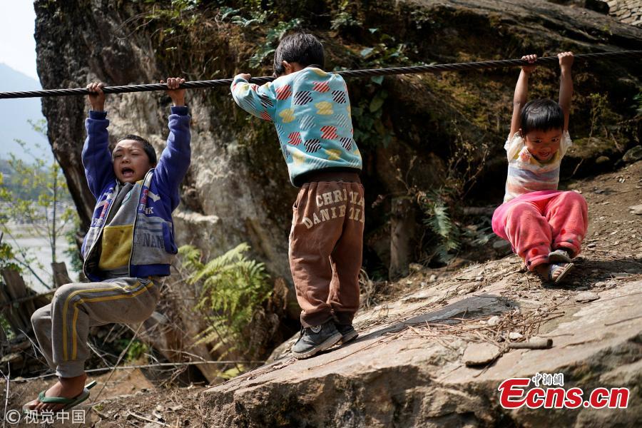 Village children play with a zipline cable in Nujiang Lisu Autonomous Prefecture in Southwest China’s Yunnan Province. Villagers have to use a zipline to cross the raging river. (Photo/VCG)