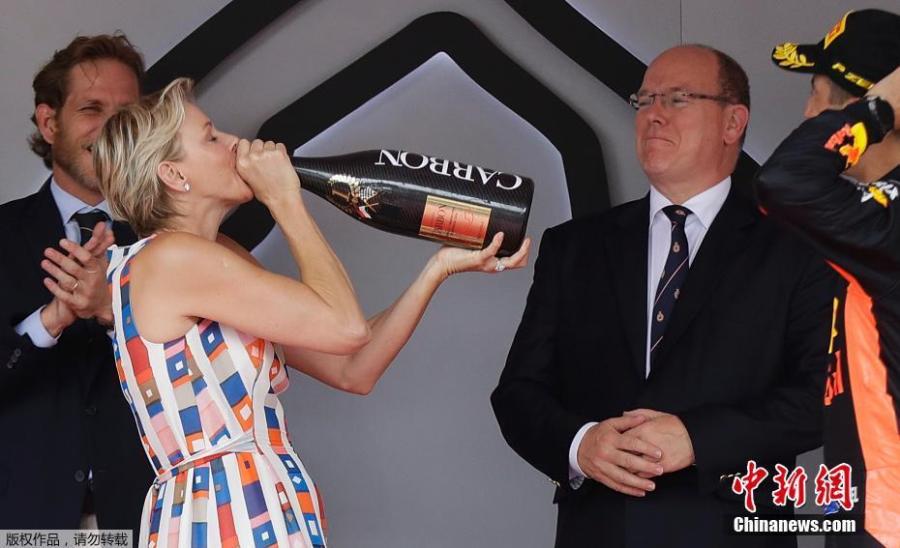 Princess Charlene of Monaco drinks the winner\'s champagne from the bottle as Daniel Ricciardo cheers her on in Monte Carlo, Monaco, May 27, 2018. (Photo/Agencies)