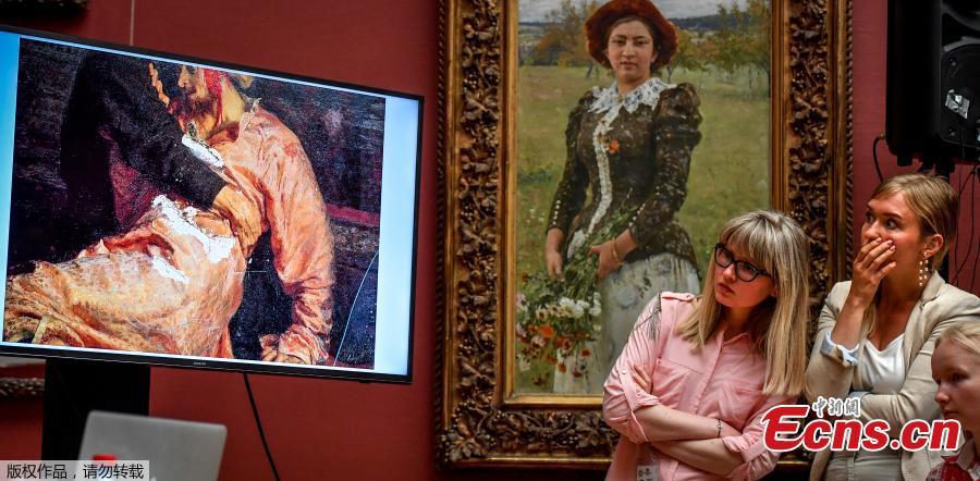 Two journalists look at the screen showing the damaged world famous painting of the 16th century Russian Tsar, titled \'Ivan the Terrible and his Son Ivan on November 16, 1581.\' by Ilya Repin during a press conference at the Russian State Tretyakov Gallery in Moscow on May 28, 2018. Russian police on Saturday said they arrested a man for vandalising one of the best known works of 19th century painter Ilya Repin, depicting Ivan the Terrible killing his son, at a gallery in Moscow. (Photo/Agencies)