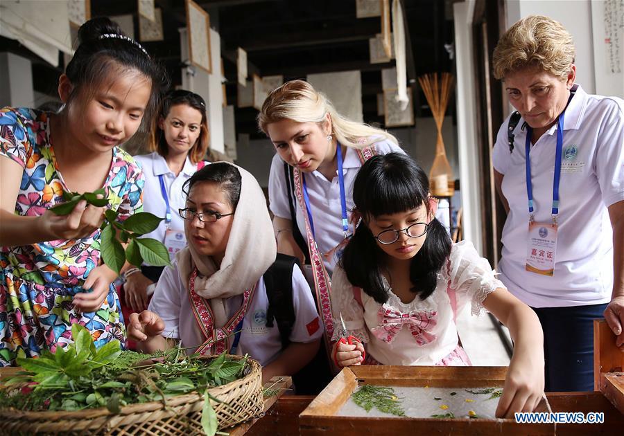 Foreign craftsmen learn the production techniques of Huacao Paper, a kind of traditional Chinese handmade paper, at Wanda Village of Danzhai County in Qiandongnan Miao and Dong Autonomous Prefecture, southwest China\'s Guizhou Province, Aug. 15, 2017. The Second Shanghai Cooperation Organization (SCO) Summer Camp, featuring sino-foreign exchanges of intangible cultural heritages, was held here. The 18th Shanghai Cooperation Organization (SCO) Summit is scheduled for June 9 to 10 in Qingdao, a coastal city in east China\'s Shandong Province. Since China took over the rotating presidency of the SCO last June, more than 160 activities including a series of important institutional meetings and multilateral events have been held so far. (Xinhua/Huang Xiaohai)