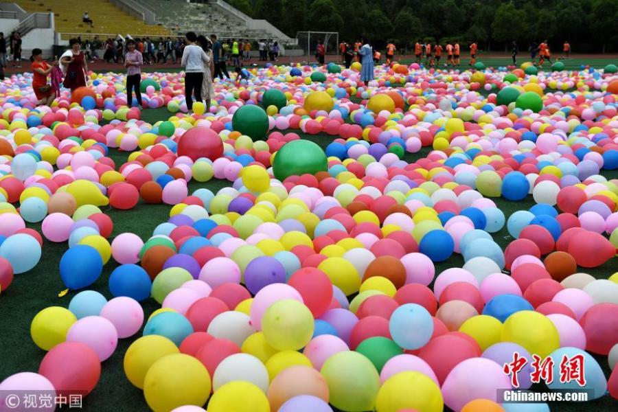 Senior high school pupils trample balloons in an activity to relieve stress ahead of the National College Entrance Exams, or Gaokao, at No.1 High School in Hefei City, East China’s Anhui Province, May 28, 2018. The school prepared 20,000 balloons to allow some 2,000 students a fun break from the test stress. (Photo/VCG)
